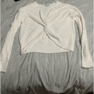 Fuzzy white cropped sweater, hangs off the shoulders.